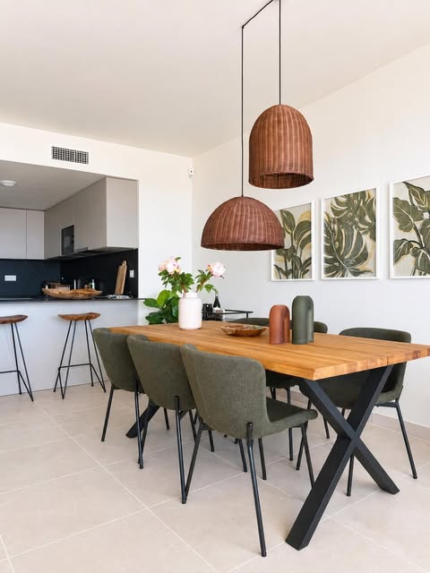 Completed open plan kitchen with oak dining table and olive green chairs